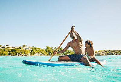 Father and son paddling boarding in the ocean